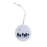 The&nbsp;"Merry Christmas" Porcelain Heart Ornament features two pine trees and a coy cabin with stars and a snowy background. The back of the ornament features&nbsp;six pine trees with the same snowy, starry sky.  2" Dia