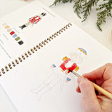 Watercolor workbooks are just like a coloring book, but with watercolor! Enjoy this peaceful hobby on your own, with kids, and with friends. Makes a wonderful gift. Perfect for artists of any age. This Nutcracker book has beautiful illustrations of scenes from The Nutcracker for you to paint!

12 beginner-friendly, lightly sketched illustrations

Simple step-by-step instructions and example

Lay flat spiral pages for easy painting

Durable 120 lb watercolor paper

Travel ready 6.5 inch x 9 inch size

Paint 