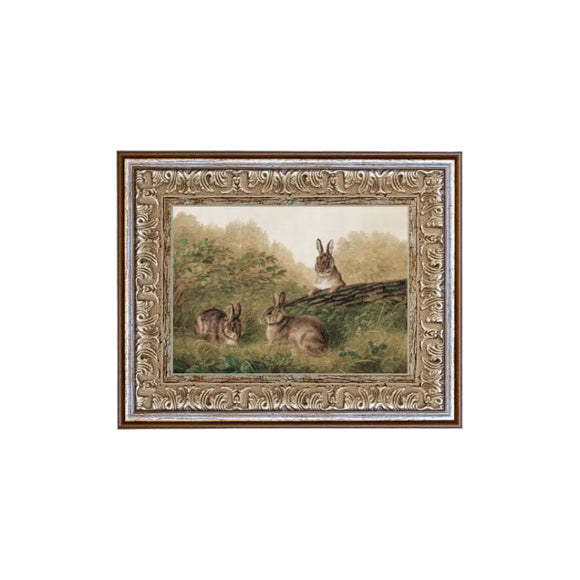 We are obsessed with this little works of art! Three brown bunnies are playing in the woods around a log. You'll find lots of places to put this mini artwork! Printed on premium canvas fabric for a lasting, textured finish and has a handcrafted ornate frame that adds a classic charm.  Comes with a paper backing and hanging hardware for easy installation.

Made in the USA: Proudly crafted with quality and care. 

Care Instructions: Keep canvas dry to maintain its quality. If smudged or dirty, 