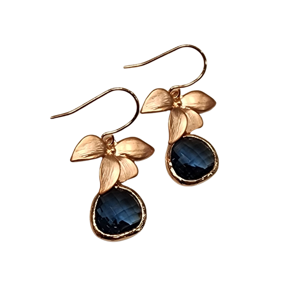 These are beautiful matte rose gold and Montana Blue glass orchid dangle earrings. The sparkling blue faceted glass jewel is framed in rose gold plated brass and it drops below the matte rose gold flower. The ear wires are nickel free gold plated brass.

Length: Flower and glass jewel - approx 1