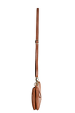 Meet Nicolette, our sleek, curvy cognac colored crossbody pochette with a minimalist style. Featuring soft sculptural curves in tumbled vegan leather, this bag is closed with a brass zipper that encloses 3 interior compartments to keep your cards, cash, keys and phone stowed neatly. The gleaming brass rings open to swap out the two included shoulder straps. A short strap for dressier looks and a longer adjustable crossbody strap when you want to go hands free. Available in an array of beautiful colors, the 