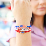 Show your patriotic spirit in style with this vibrant Stars &amp; Stripes bracelet set, featuring four unique Americana-inspired designs crafted with colorful acrylic beads and gold accents. Perfect for Fourth of July, Memorial Day, or any summer gathering, these cheerful bracelets add a festive finishing touch to your party look and make celebrating with friends even more memorable.

You'll receive four 6" bracelets:

Red, white &amp; blue beaded bracelet with "USA" beads with two gold beads on either side