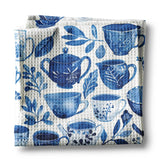 These towels are perfect home and kitchen decor, and also makes a great hostess gift for your next tea party! Blue teacups, teapots and botanical leaves are scattered all over this beautiful white towel.

Measures approximately 16”x 24”

Made of 80% Polyester and 20% Polyamide.

Design is permanently printed - Single side across whole towel

It is called a waffle weave because the towel has raised looped edges on the surface of the towel in the shape like that on a delicious Belgian Waffle. These “pockets''