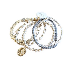 You'll love this five-piece stretch Boho Beaded Bracelet Stack! It features a gorgeous combination of metal and grey-toned glass beads and a worn silver-toned coin. It's perfect for any season and great to combine with other bracelets for a thicker bracelet stack!  Stretchy bracelet, one size fits most.