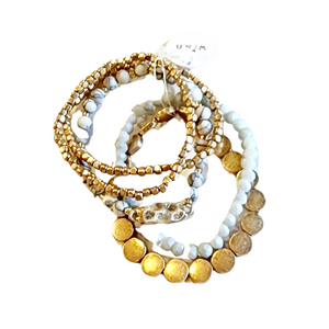 You'll love this five-piece stretch Boho Beaded Bracelet Stack! It consists of a semi-precious metal and howlite glass beaded bracelet, a howlite bracelet with a golden nugget centerpiece, a golden nugget flat beaded bracelet, and two golden nugget bracelets. It's perfect for any season and great to combine with other bracelets for a thicker bracelet stack!  Stretchy bracelet, one size fits most.