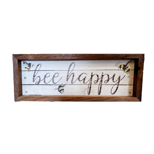 We love these made-in-the-USA signs! This cute sign has the words "bee happy" in cursive font on top of a whitewashed wood pallet background with three bees flying around.  It has a wooden frame surrounding it.  It is made from high-quality American hardwood planks with a hand-painted face, printed with UV-cured ink, and framed in a natural walnut frame. Each piece is unique with its own personality, marks, wood grain, and look. Easy to clean with a dry cloth.  Made in the USA  12 x 4 x 1.5