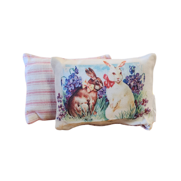 This adorable mini vintage postcard pillow has a brown bunny and white bunny in a field of violets. Below it says 