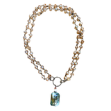 This chain and bead mixed necklace has bronze links and taupe blush translucent bead. It has a blue translucent pendant attached by a jump ring. This is one continuous strand with no lobster claw clasp. This can be worn long or short, by attaching the small hook to the jump ring for a double-layer look.

Length of beaded chain (not including jump ring and dangle pendant): 18" Length from top to bottom of pendant: Approx 20.5" Pendant :1" L 1/2 W Jump ring : 1"