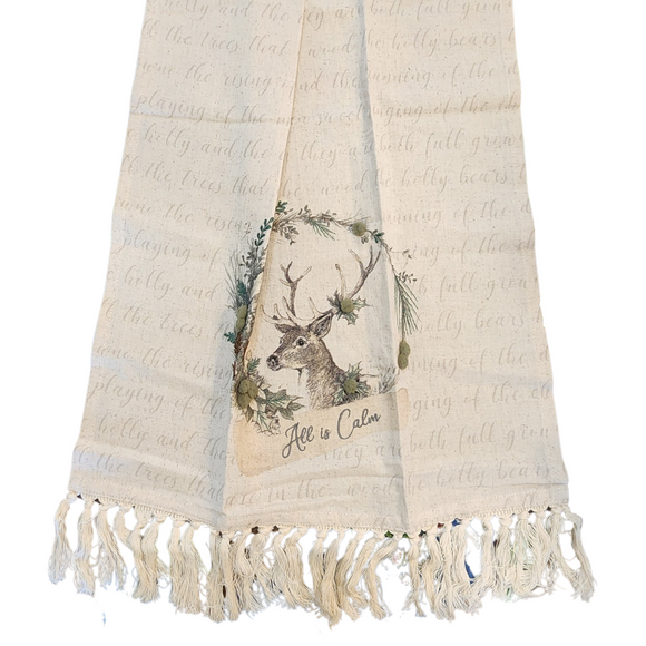 This stunning kitchen towel showcases a graceful deer at the heart of an embroidered wreath, beautifully accented with greyish green felt balls. The phrase 