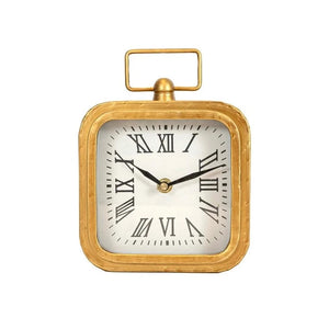 This brass square tabletop clock with rounded edges will add a timeless touch to your home. It's a perfect blend of modern and traditional design elements that will elevate any room. The brushed brass finish offers a luxurious look that enhances the square shape and decorative handle on top.&nbsp;  6 x 2.3 x 8 in  -Ticking mechanism.&nbsp;Material: Metal, Wood &amp; Glass, Requires 1 AA Battery (Not Included)