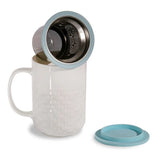 This 15oz Weave tea infuser mug is made from new bone china and has a blue silicone top. The exterior of the tea infuser mug features a weave-textured design. The top part of the mug where you drink is a smooth finish. The mug's interior is white, allowing you to see the color of the tea. The mug includes a stainless steel filter for loose-leaf tea and tea bags. The mug has a comfortable handle and a nice weight and feel. It is not too heavy. The handle does not get hot in the microwave.