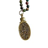 A beautiful long necklace with sections of glass beading with knots in between each bead with a gorgeous oval India Agate pendant that has a flower detail at the top of the stone. The back of pendant is bronze with scrolled details&nbsp;

Please expect some variation in color/texture due to natural material.

Length: 17" L ( 34" total) with a 2" L pendant