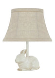 This little bunny lamp is perfect for a powder room, bedroom, or bookcase. Use it as a night light or accent light. The natural cotton/linen shade features a tan contrasting trim that accentuates the light brown accent on the bunny's paws, ears, and tail.  25-watt bulb not included.  12" H x 6" D x 9.5" W with lampshade