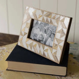 This photo frame will add a unique farmhouse touch to your decor and grab the attention of anyone who enters your home. The white resin geometric pattern highlights the natural grain of the mango wood, creating an eye-catching display for your most treasured photo memories.  7"H&nbsp; x 0.5"D x 9" L&nbsp;