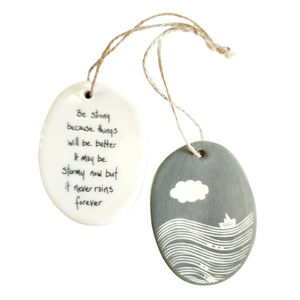 We love our porcelain ornaments because they are perfect for gift-giving! This oval ornament says, "Be strong because things will be better.&nbsp; It may be stormy now, but it never rains forever" on one side. On the other side is a grey background with a cloud over the water with a sailboat in white.&nbsp;


Dimensions:&nbsp;2" W x 2 3/4" H