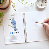 The Birds Watercolor Workbook includes 12 bird illustrations with an example of the finished painting, step-by-step instructions, and a lightly illustrated sketch for you to paint. It's just like a coloring book, but with watercolor! Enjoy this peaceful painting hobby on your own, with children, or with friends. Makes a wonderful gift and is perfect for artists of any age.

Details: - 12 beginner-friendly illustrations

Thick 120lb watercolor paper

&nbsp;Lay-flat pages with spiral binding for hassle-free p