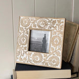 This beautiful carved floral mango wood picture frame holds a 4x4 photo and is the perfect addition to your home decor! Details of the intricately carved floral design are enhanced by a heavy whitewash, making the pattern on the frame border pop from the natural mango wood.&nbsp;