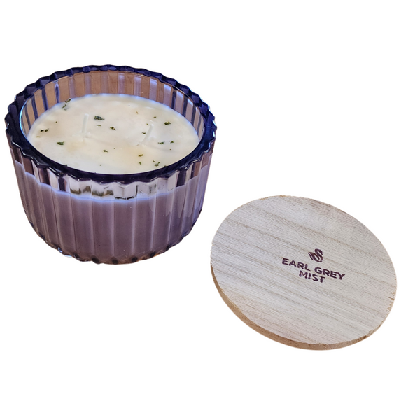 You'll love our new cathedral bowl candle style and size! This Earl Grey Mist candle has been poured into a pretty purple-patterned glass and comes with a wooden lid.

Grab a cup and be prepared to fill your home with a cozy mist of bright citrus, spicy black tea, subdued florals and herbal lavender. Subtle hints of sugared milk, soft vanilla, and dried rosemary add complexity and serve to smooth out the blend. A lovely and peaceful sensory experience for any time of the year- like an indoor picnic for the 