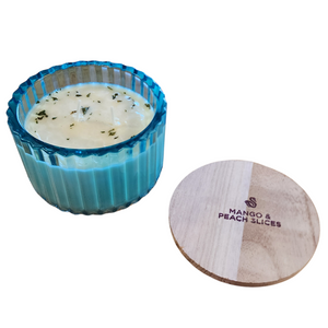 You'll love our new cathedral bowl candle style and size! This mango &amp; peach slices candle has been poured into a pretty blue-patterned glass and comes with a wooden lid.

Fresh juicy peaches meet sweet mangos for the delightful fruity fragrance sure to please all!

Scent profile: Top: Strawberry Sugar, Cloudberry Jam Middle: Saltwater Taffy, Vanill