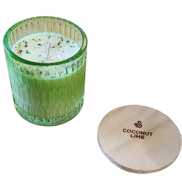 You'll love our newest cathedral glass tumbler! This coconut lime has been poured into a pretty green patterned glass and comes with a wooden lid.

Fresh limes mixed with the sweetness of coconut transports you to a warm sandy beach to relax!

Filled with 6.5 oz. of American Soybean WaxTM. Measures 3.25