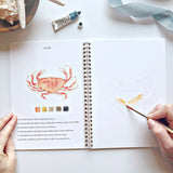 Watercolor workbooks are just like a coloring book, but with watercolor! Enjoy this peaceful hobby on your own, with kids, and with friends. Makes a wonderful gift. Perfect for artists of any age. This Seaside book has beautiful illustrations of boats, crabs, anchors, oars and more for you to paint!

12 beginner-friendly, lightly sketched illustrations

Simple step-by-step instructions and example

Lay flat spiral pages for easy painting

Durable 120 lb watercolor paper

Travel ready 6.5 inch x 9 inch size
