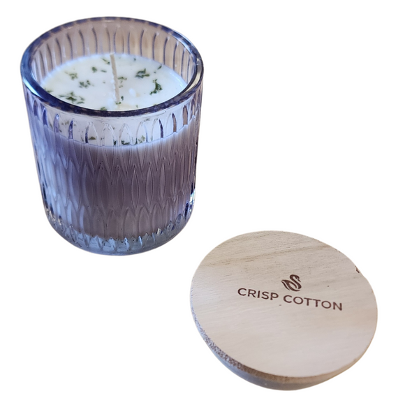 You'll love our newest cathedral glass tumbler! This crisp cotton has been poured into a pretty purple patterned glass and comes with a wooden lid.

Fresh air blended with clean linen; a year-round customer favorite!

Filled with 6.5 oz. of American Soybean WaxTM. Measures 3.25
