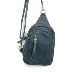 Blending uptown chic with downtown cool, the Skyler sling bag is made in rich dark teal colored vegan leather! A convertible strap lends versatility, while a front zip pocket offers practical storage for your necessities. It is the perfect companion for a night out on the town or a fun day trip!   8" h x 5.5" w&nbsp; x 2.25" d