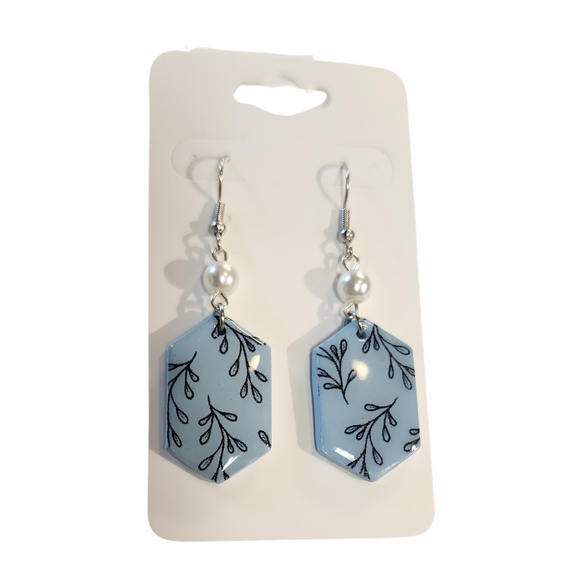 You will love these lightweight, trendy polymer clay earrings in a fun elongated hexagon shape with black leaves all over a soft blue background. This pair of clay earrings is coated with a resin layer to give them a pretty shine and finished look! The earring hooks are comfortable and easy to wear and made of high-quality, strong/durable stainless steel, which is hypoallergenic and nickel-free. * 

This versatile earring design would accompany any outfit, from casual to dressed up! 

Handcrafted 