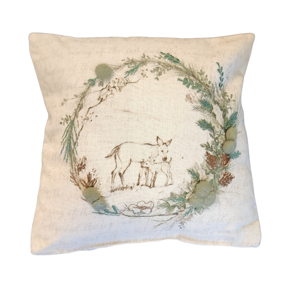 This beautiful mini pillow shows a sweet scene of a doe and her fawn in the center of an embroidered wreath, beautifully accented with greyish green felt balls. Crafted from a soft muslin cream fabric adorned with whimsical writing, this pillow is a charming decor piece for your home!

8