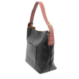 Equally timeless and modern, our best-selling classic hobo is made in rich vegan leather in a beautiful black, accented with a brown strap.  This roomy bag, accented with a large front pocket and a snap-in removable brown crossbody, has plenty of room to carry your needs in style.