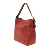 Equally timeless and modern, our best-selling classic hobo is made in rich vegan leather in a beautiful deep berry color, accented with a brown strap.  This roomy bag, accented with a large front pocket and a snap-in removable brown crossbody, has plenty of room to carry your needs in style.
