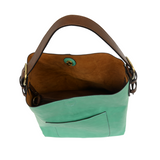 Equally timeless and modern, our best-selling classic hobo is made in rich vegan leather in a beautiful seafoam color, accented with a coffee brown strap.  This roomy bag, accented with a large front pocket and a snap-in removable brown crossbody, has plenty of room to carry your needs in style. MAIN BAG 12" h x 14" w x 6" d  Adjustable strap 6"-11"  Magnetic snap top closure  Exterior open pocket