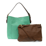 Equally timeless and modern, our best-selling classic hobo is made in rich vegan leather in a beautiful seafoam color, accented with a coffee brown strap.  This roomy bag, accented with a large front pocket and a snap-in removable brown crossbody, has plenty of room to carry your needs in style. MAIN BAG 12" h x 14" w x 6" d  Adjustable strap 6"-11"  Magnetic snap top closure  Exterior open pocket