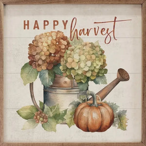 This mini-art will steal the show! A pumpkin sits below a watering can that has hydrangeas in it. Above, the words "Happy Harvest" is in an orange mixed font.
