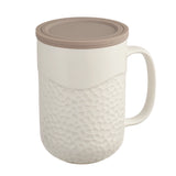 This 15oz Coral design tea infuser mug is made from new bone china and has a grey silicone top. The exterior of the tea infuser mug features a coral-textured design. The top part of the mug where you drink is a smooth finish. The mug's interior is white, allowing you to see the color of the tea. The mug includes a stainless steel filter for loose-leaf tea and tea bags. The mug has a comfortable handle and a nice weight and feel. It is not too heavy. The handle does not get hot in the microwave.