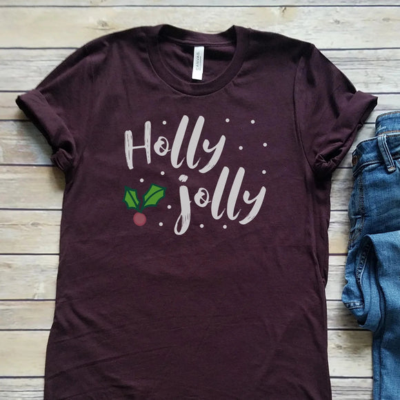 Our Holly Jolly T-shirt is a deep shade of plum with the words 
