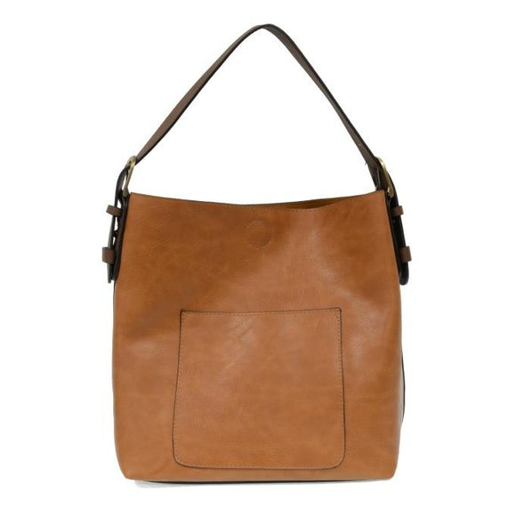 Equally timeless and modern, our best-selling classic hobo is made in rich vegan leather in a beautiful hazelnut color, accented with a dark brown strap.  This roomy bag, accented with a large front pocket and a snap-in removable brown crossbody, has plenty of room to carry your needs in style.