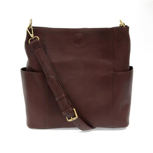 Casual and carefree crossbody in super soft pebble grain vegan leather! The convenient side pockets carry your water bottle, phone or glasses.  11" W X 11.25" H X 3.5" Magnetic Snap Closure 2 open and 1 zipper interior pockets 2 exterior open pockets and 1 back zipper pocket 12- 18" adjustable drop and detachable crossbody strap with lobster claw clasps Brushed lining Brass plated hardware 100% vegan leather (polyurethane)