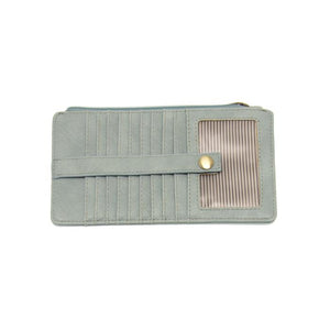 This slim and sleek wallet has nine credit card pockets, each with a snap tab for security and brass-plated hardware. It also has an ID window, zippered change pocket, and zippered billfold pocket in distressed bluebird skies vegan leather.


DIMENSIONS: 3.75 IN. H X 7.25 IN. W X .25 IN. D&nbsp;


100% Vegan leather (polyurethane)
