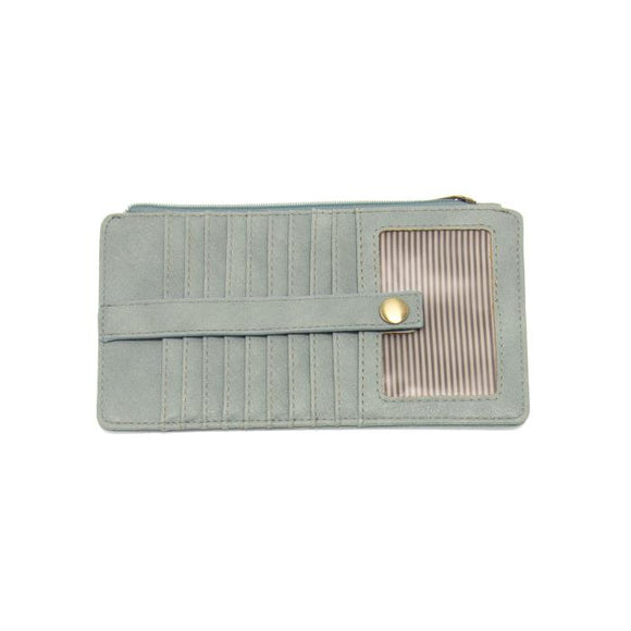 This slim and sleek wallet has nine credit card pockets, each with a snap tab for security and brass-plated hardware. It also has an ID window, zippered change pocket, and zippered billfold pocket in distressed bluebird skies vegan leather.


DIMENSIONS: 3.75 IN. H X 7.25 IN. W X .25 IN. D 


100% Vegan leather (polyurethane)