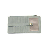 This slim and sleek wallet has nine credit card pockets, each with a snap tab for security and brass-plated hardware. It also has an ID window, zippered change pocket, and zippered billfold pocket in distressed bluebird skies vegan leather.


DIMENSIONS: 3.75 IN. H X 7.25 IN. W X .25 IN. D&nbsp;


100% Vegan leather (polyurethane)