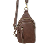 Blending uptown chic with downtown cool, the Skyler sling bag is made in rich vegan mocha brown leather! A convertible strap lends versatility, while a front zip pocket offers practical storage for your necessities. It is the perfect companion for a night out on the town or a fun day trip!  8" h x 5.5" w  x 2.25" d