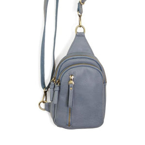 Blending uptown chic with downtown cool, the Skyler sling bag is made in rich vegan denim blue leather! A convertible strap lends versatility, while a front zip pocket offers practical storage for your necessities. It is the perfect companion for a night out on the town or a fun day trip!  8" h x 5.5" w  x 2.25" d Removable and adjustable convertible strap 20"-30" drop Zippered top closure Exterior front zip pocket