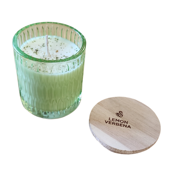 You'll love our newest cathedral glass tumbler! This lemon verbena candle has been poured into a pretty green patterned glass and comes with a wooden lid.

Refreshing, citrusy and green - the perfect summer harmony! This aromatic-herbal blend is both calming and energizing as the crisp lemon notes lift the grass-like verbena and slightly-bitter olive leaf. A base of earthy teak and sandalwood provide the perfect balance!

Filled with 6.5 oz. of American Soybean WaxTM. Measures 3.25