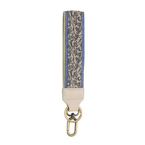 We love these wristlet keychain/wristlet straps. They are comfortable to wear and look super cute - pick up a few for yourself & gifts!  1.5" white strap with blue stripes along the outside and a black scroll pattern on a white background