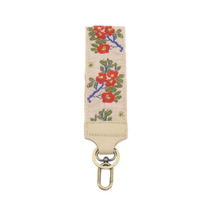 We love these wristlet keychain/wristlet straps. They are comfortable to wear and look super cute - pick up a few for yourself &amp; gifts!

2" cream strap with red flowers with yellow centers on cobalt blue branches with olive green leaves.