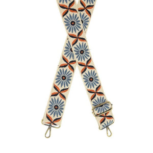 You'll love changing up the style of your purse with one of our guitar straps! This cream woven strap has blue daisies with black and orange centers going down it - so cute! The back of the strap is solid cream.  35"-54" adjustable length  2" wide  Brass plated hardware