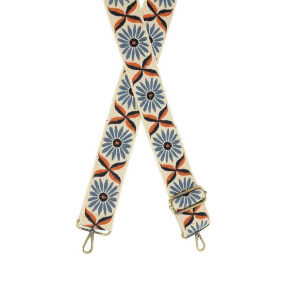 You'll love changing up the style of your purse with one of our guitar straps! This cream woven strap has blue daisies with black and orange centers going down it - so cute! The back of the strap is solid cream.  35