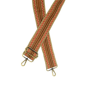 Time to change things up!  This guitar strap will give your bag a new look instantly!  Light and dark pink triangle border around three beautiful copper stripes with a bit of sparkle down the center, all on a natural tan background.  The back of the strap is the same tan as the front.  2" wide  35"-54" adjustable length  80% Polyester 20% Cotton  Brass plated hardware 
