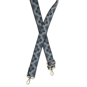 You'll love changing up the style of your purse with one of our guitar straps! This blue woven strap has teal/green and purple daisies going down it - so cute! The back of the strap is solid black.  35"-54" adjustable length  1.5" wide  Brass plated hardware
